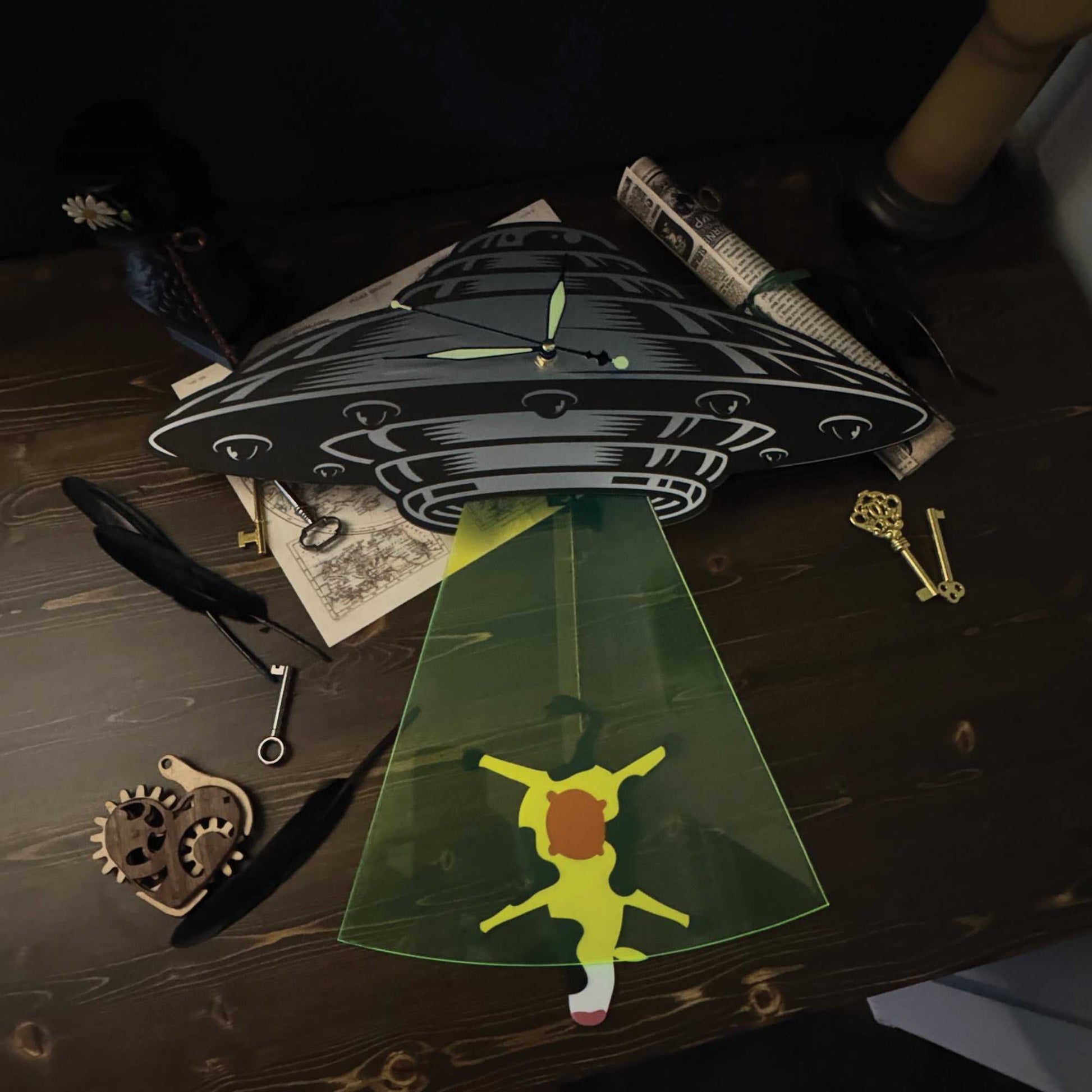  UFO-themed clock with a green light projection on a wooden surface with keys and gears.