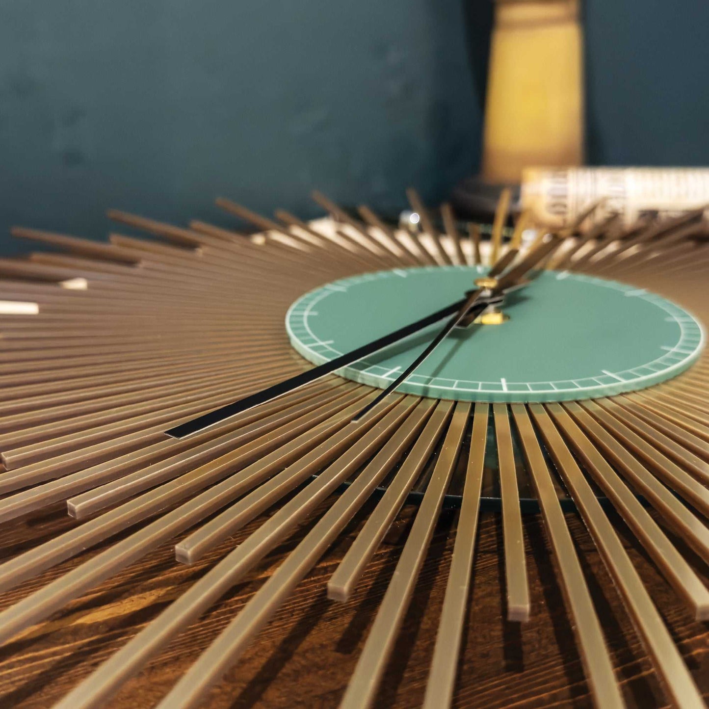 Close up of gold starburst clock on a wooden surface