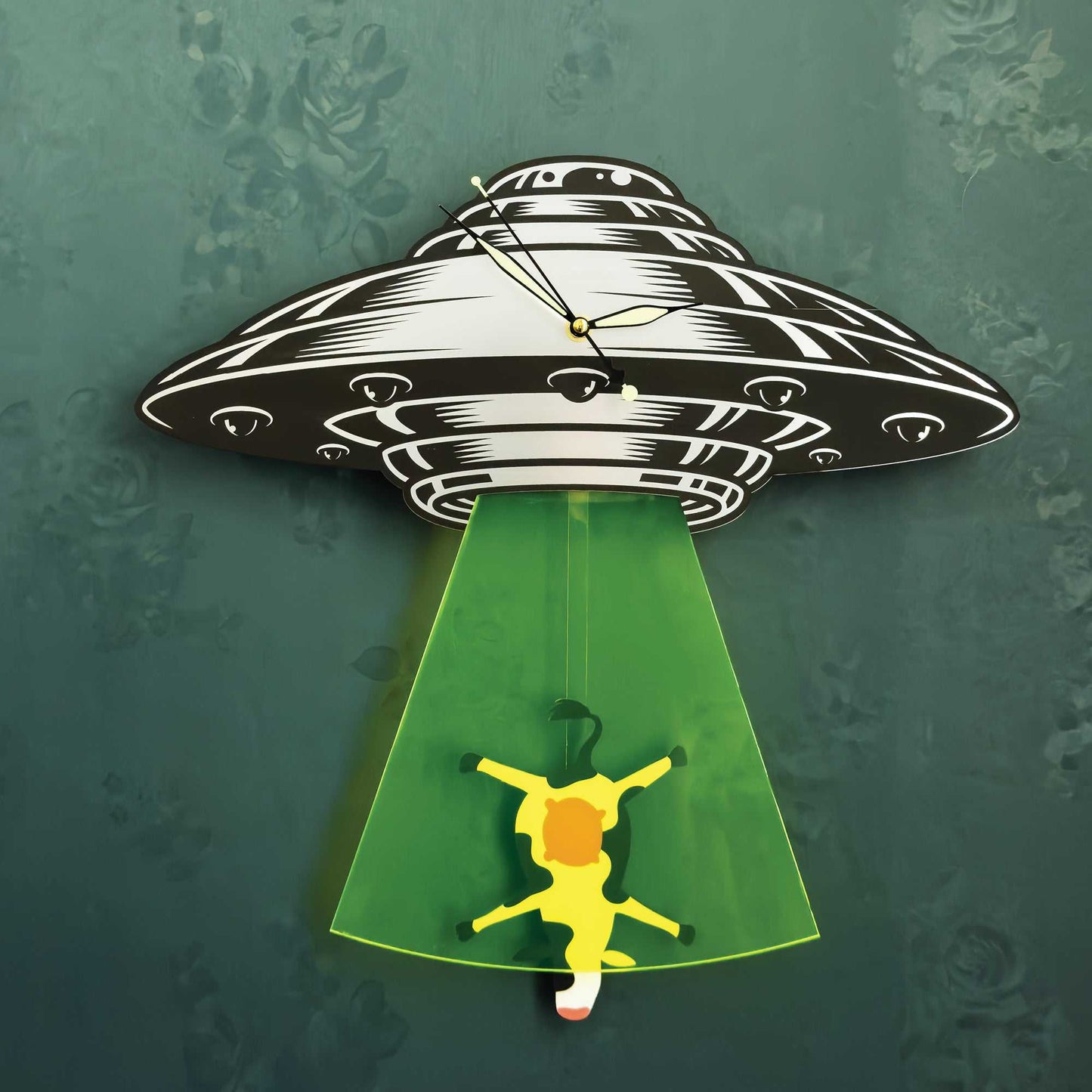 Wall clock with UFO design, green light, and yellow figure on a textured green background