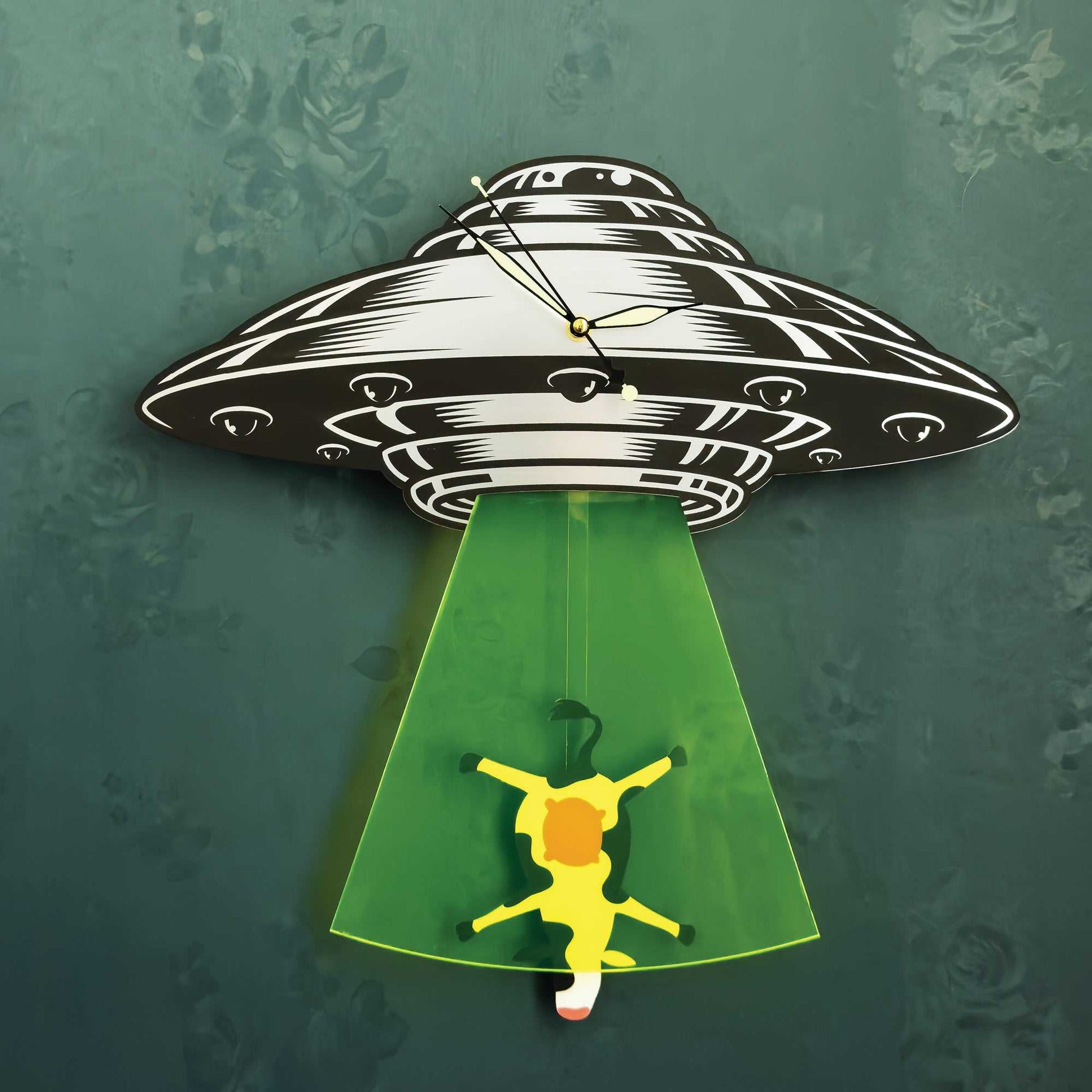 Wall clock with UFO design, green light, and yellow figure on a textured green background