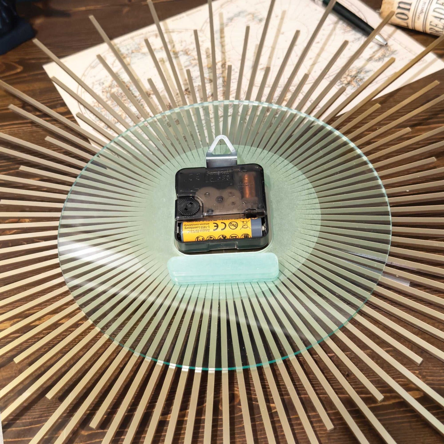 Glass plate with a battery on a wooden surface