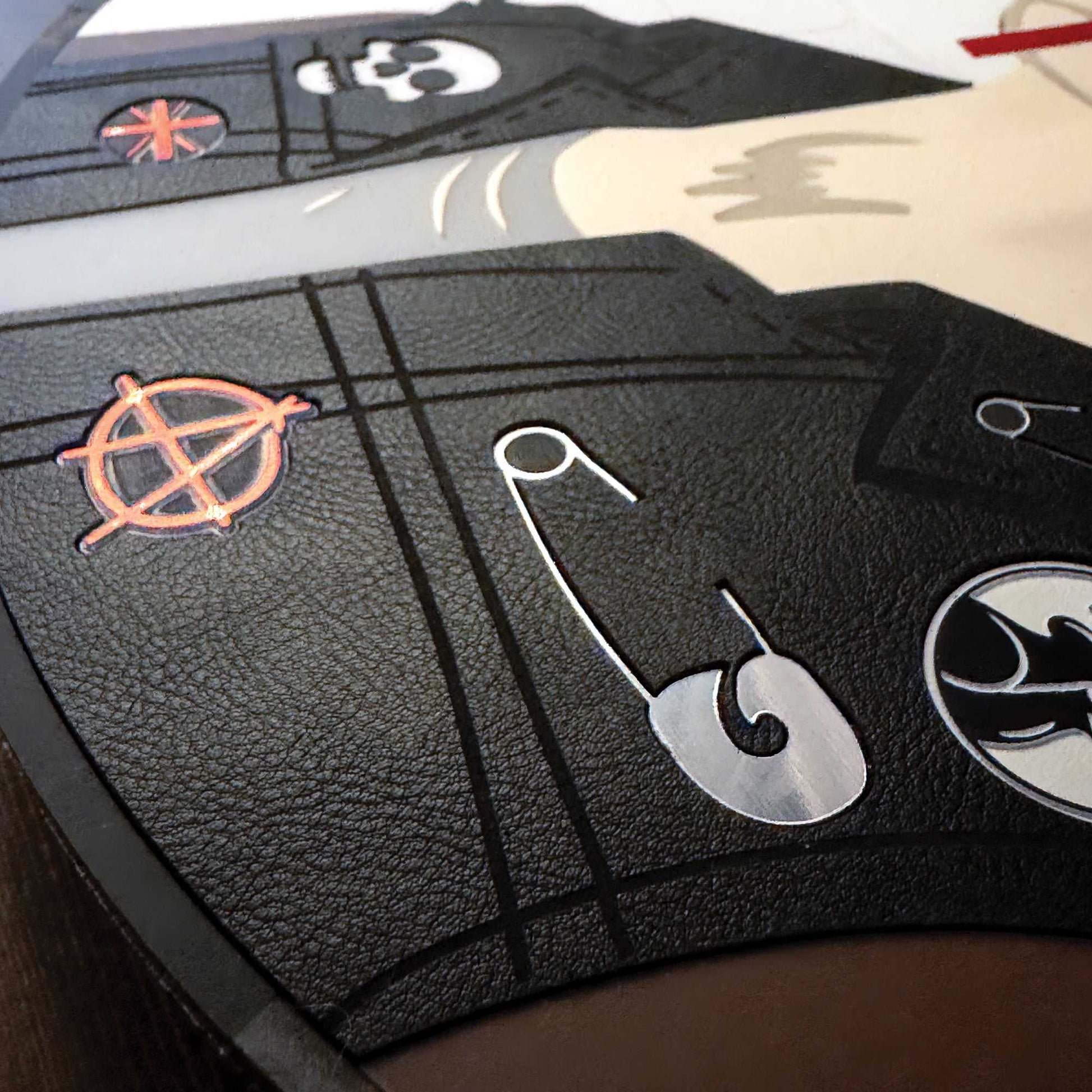 Close-up of a black leather surface with metallic symbols and designs.