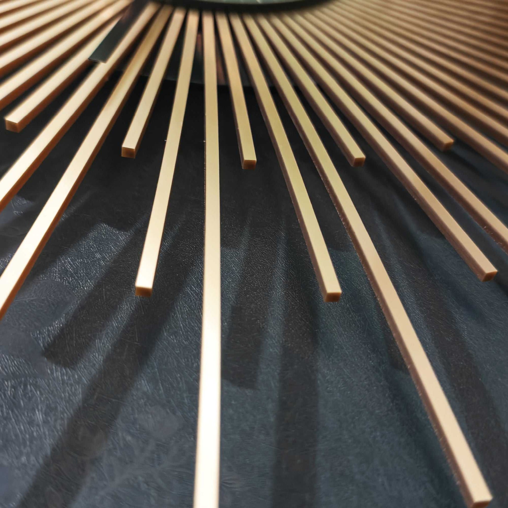 Close-up of gold sunburst design on a dark surface